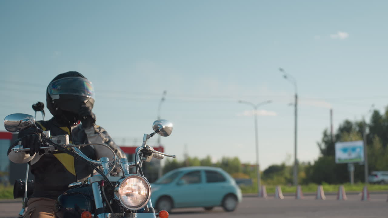 Motorcycle rider wearing helmet stops on urban road and lifts visor as woman in leather jacket approaches and begins to climb on bike, symbolizing travel and companionship