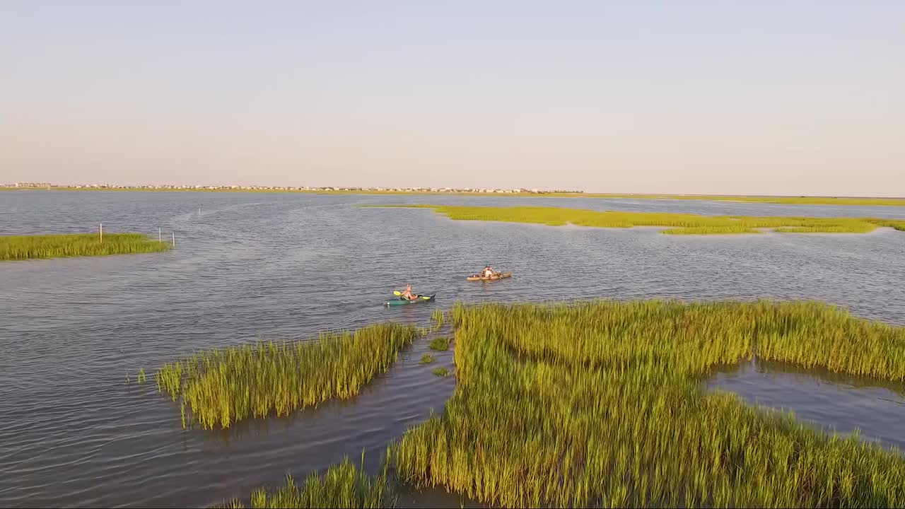 Drone che segue kayaker a Wooland Creek, vicino a Murrells Inlet, SC, al tramonto