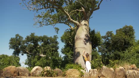 Gorgeous-Lady-Feeling-The-Texture-Of-The-Swollen-Trunk-Of-Boab-Tree