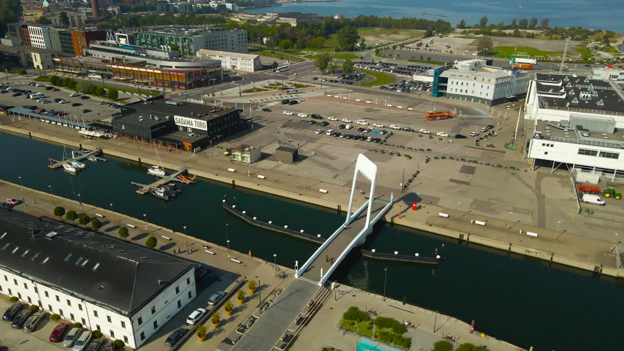 Aerial view of a cityscape with a bridge, marina, and modern architecture