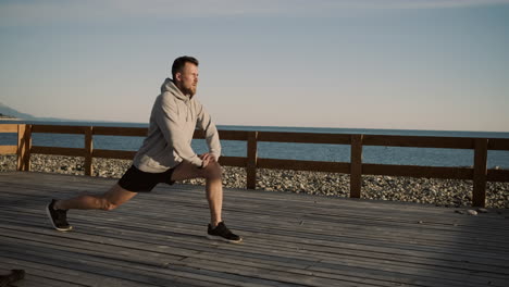 hombre estirándose en un muelle de la playa