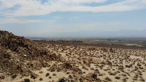 Aerial-shot-flying-over-a-desolate-dry-desert-landscape-on-a-scorching-hot-day-in-summer