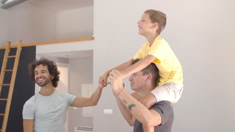 un niño alegre y emocionado montando en el cuello de su padre