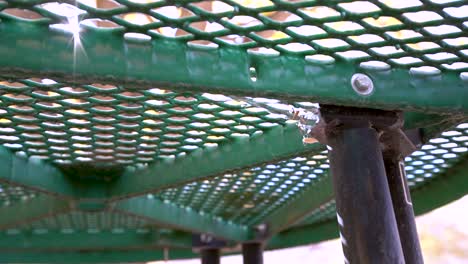 Dirty-spider-web-waving-in-the-wind-under-picnic-table-with-sun-shining-through