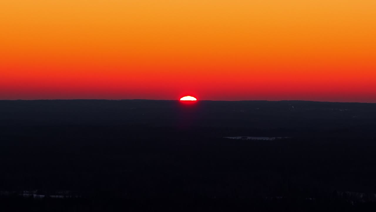Sol oplyser skyer med varmt lys under solnedgang, dramatisk farverig orange himmelbaggrund med negativ plads i luftfoto.