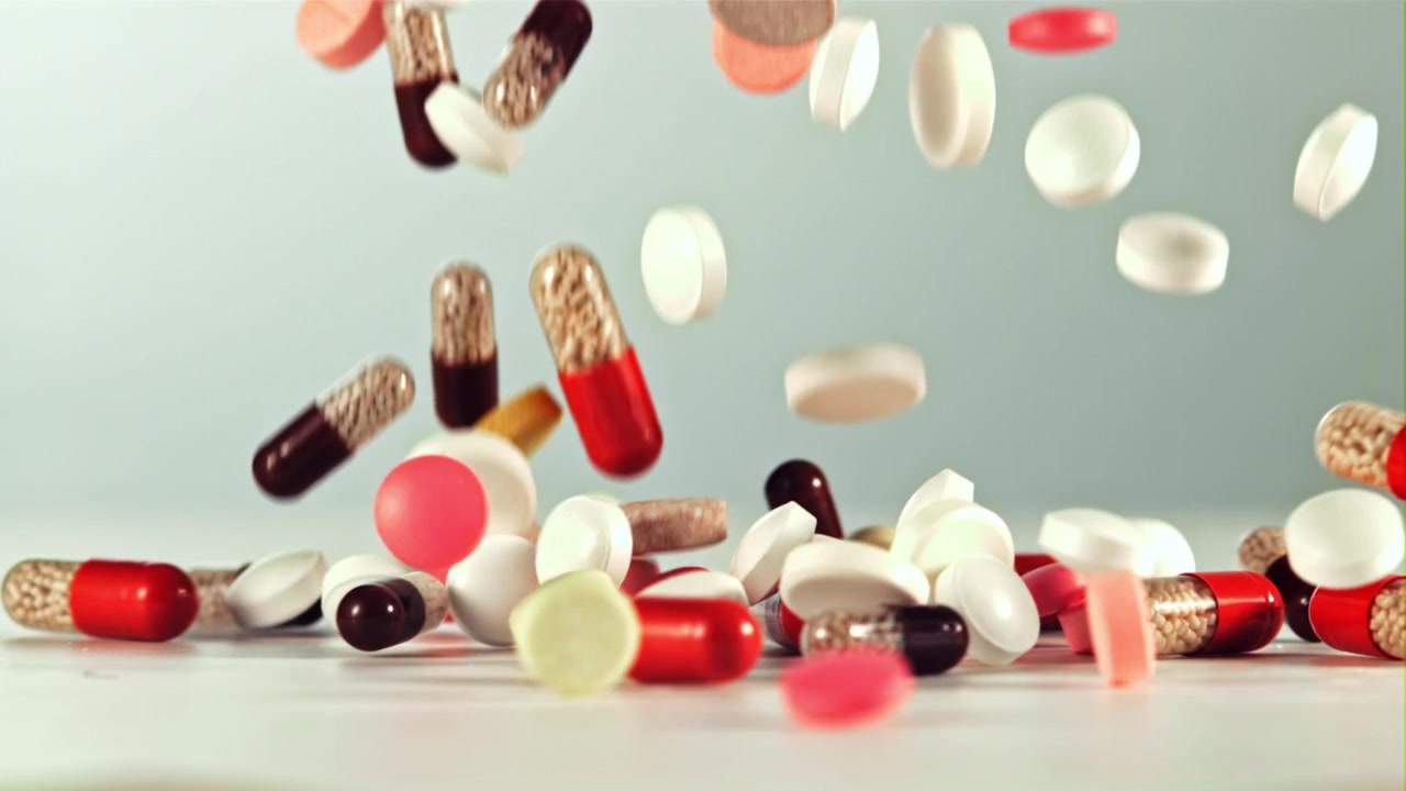 Assorted Pharmaceutical Pills and Capsules Falling in Slow Motion