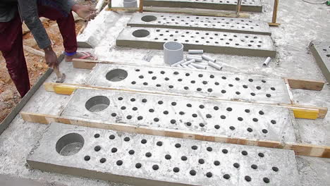 wooden slab removal by an indian mason worker using hammer to expose concrete, focus on construction process