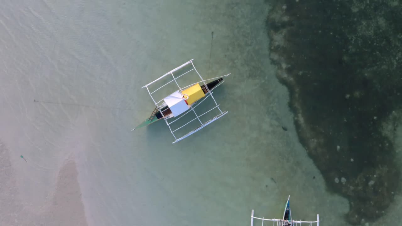 필리핀 반타의 아름다운 파라다이스 비치 해안선의 드론 촬영, 바로토 보트가 해안에 있습니다.
