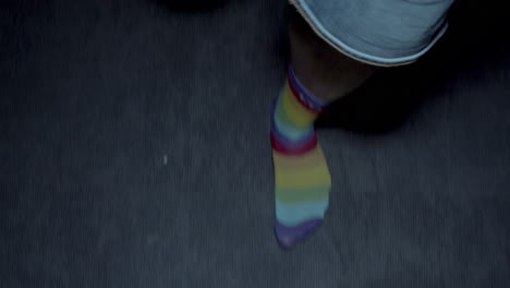 persona caminando con calcetines a rayas de arco iris
