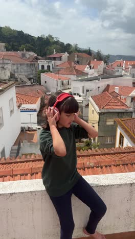 girl with headphones on rooftop