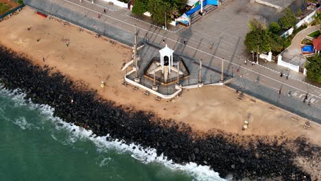 a detailed aerial shot captures the iconic gandhi statue at the heart of puducherry's promenade beach. the drone footage provides a unique overhead perspective of the statue