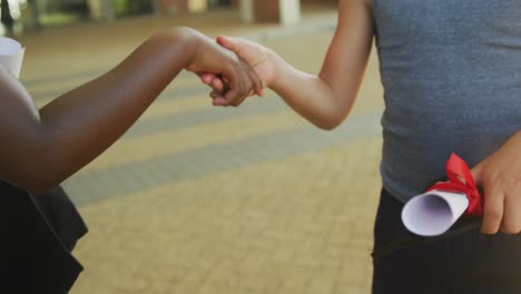 video of hands of diverse boys congratulating each other after graduation in front of school