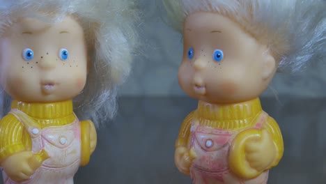primer plano de dos muñecas gemelas de juguete con pelo blanco y ojos azules
