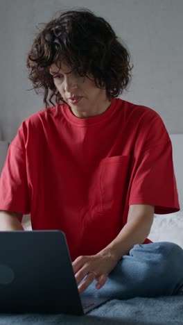 woman working on a laptop on a bed