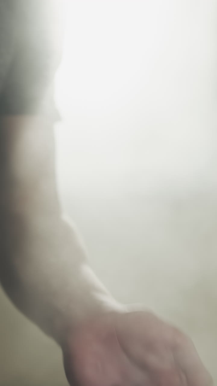 Fighter uses talc powder to dry palms in gym closeup. Young boxer prevents hand sweating with talcum in martial arts club slow motion. Athletic products