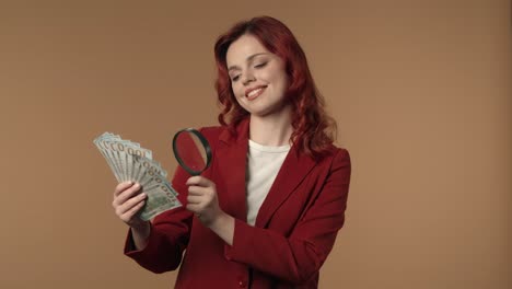 woman examining money with magnifying glass