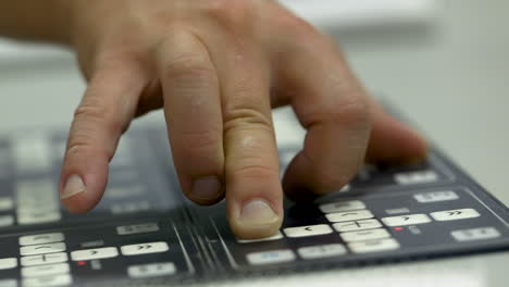 closeup of caucasian man's hand operating a machine panel
