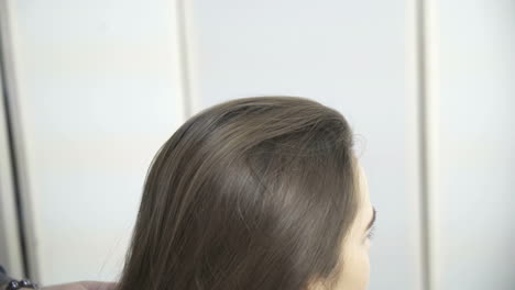 stylist dying hair. professional hairdresser dyeing hair of her client at beaty salon