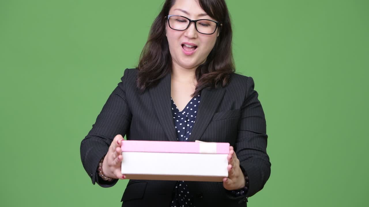 Mature beautiful Asian businesswoman receiving gift box