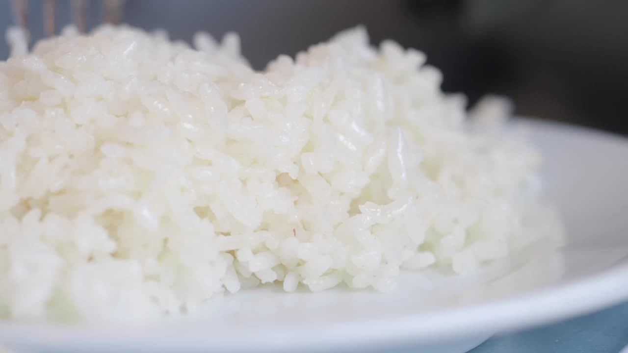 A close-up of a pile of cooked white rice on a plate
