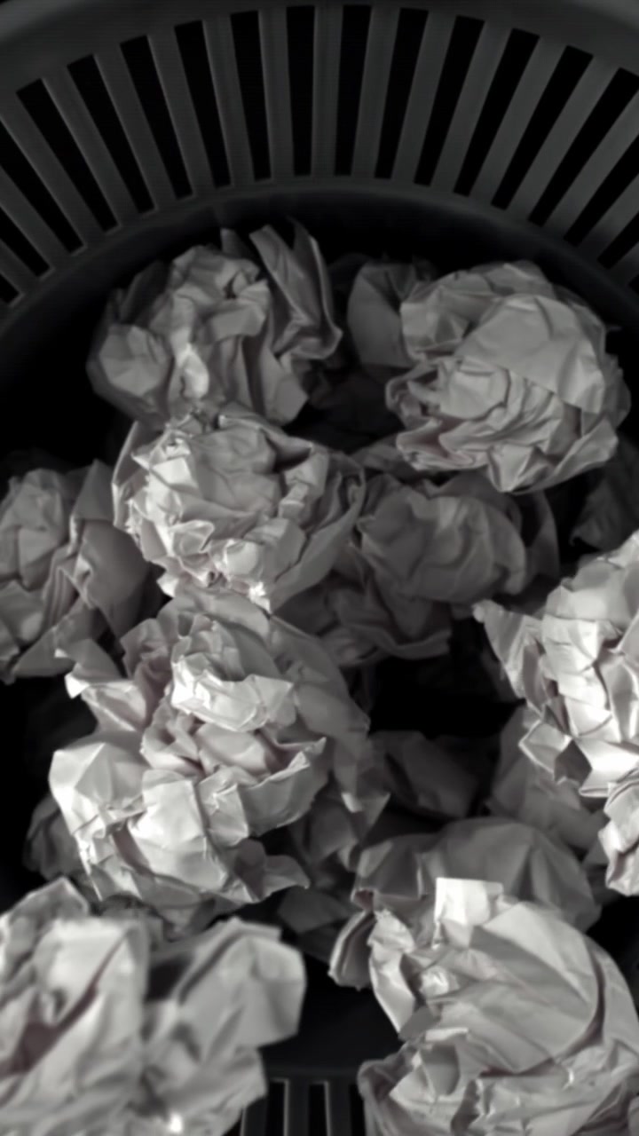 Crumpled Paper Balls Falling into a Wastebasket