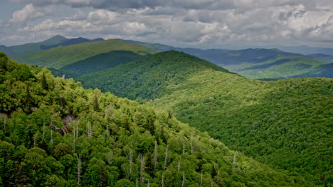dramatic aerial drone flight over the expansive smoky mountain wilderness, shrouded in fog, mist, and rain