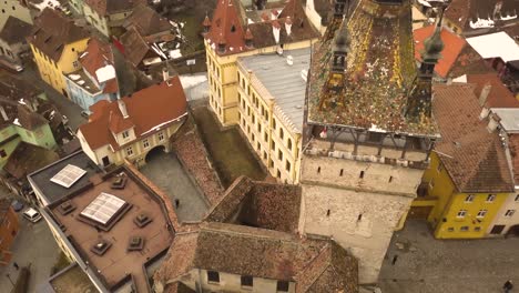 Schöne-Aussicht-Auf-Das-Dach-Des-Uhrturms-Mit-Den-Gebäuden-Der-Stadt-Sighisoara-Und-Den-Bergen-Im-Hintergrund-An-Bewölkten-Tagen