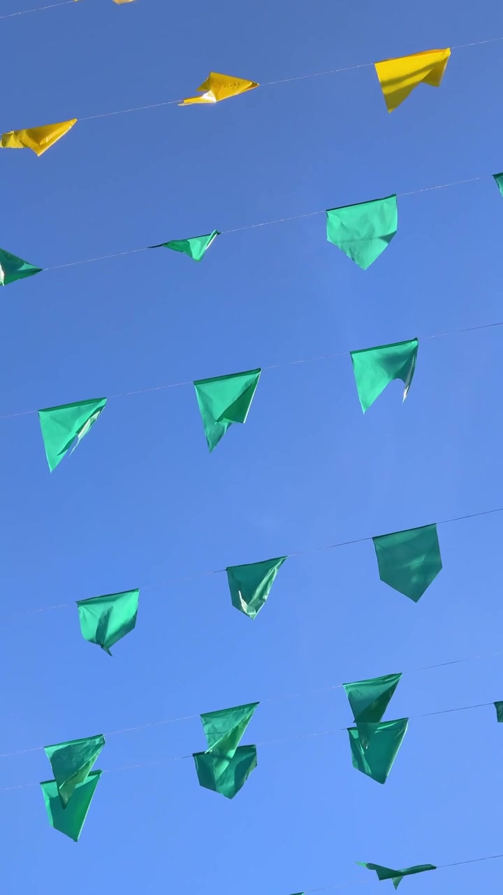 Colorful Bunting Flags Swaying Against a Clear Blue Sky