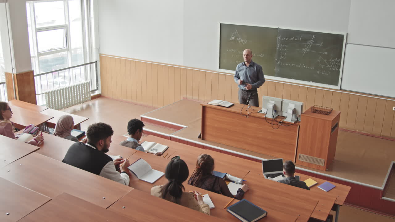 Male Professor Teaching Maths to Students in Lecture Hall