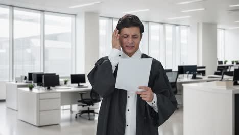 abogado indio estresado y tenso leyendo contratos