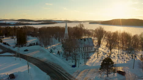 beautiful drone view of a winter sunset over a snow covered small town church