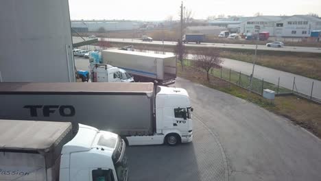 aerial view of a cargo truck moving towards a road, next to industrial buildings