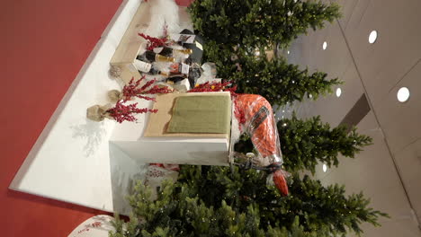 Geschenkstand-Und-Leuchtende-Weihnachtsbäume-Im-Einkaufszentrum,-Vertikale-Ansicht