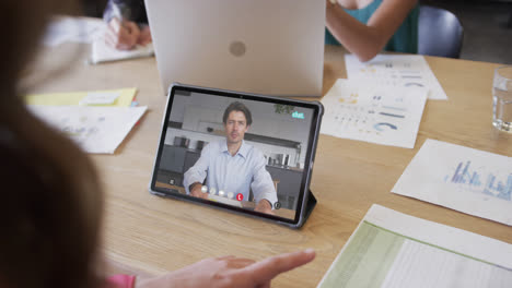 Caucasian-businessman-on-laptop-video-call-with-african-american-male-colleague-on-screen