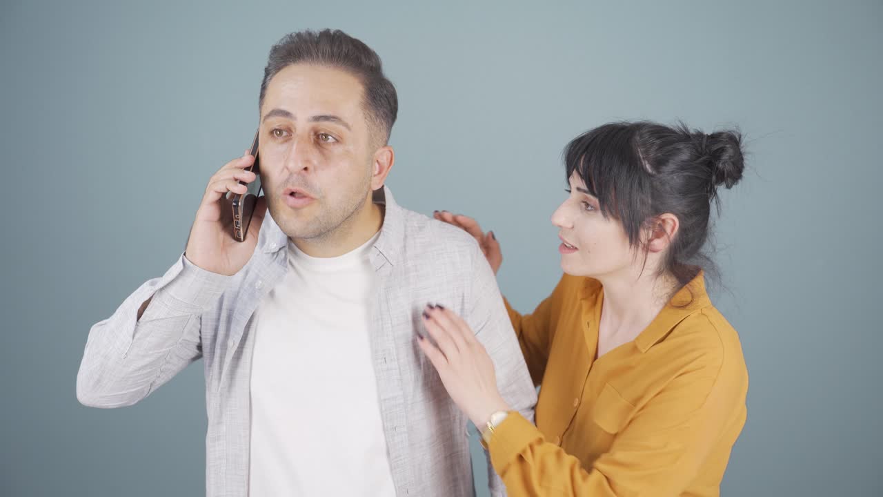 부부가 전화로 긴장해서 얘기하고 있어요.