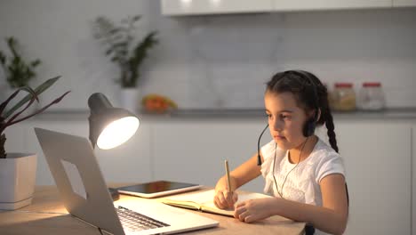 little girl kid studen studying online class with laptop at home, new normal. covid-19 coronavirus. social distancing, home schooling.