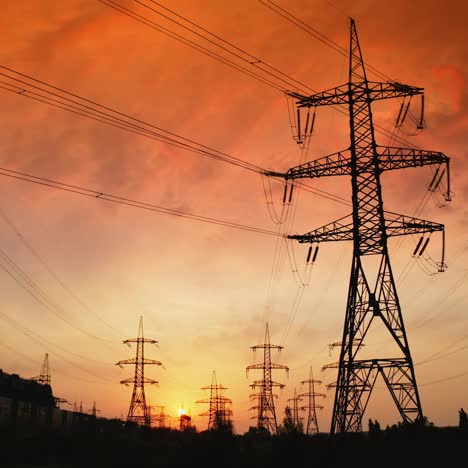 high voltage substation at sunset. electric transmission station with metal poles and electrical wires