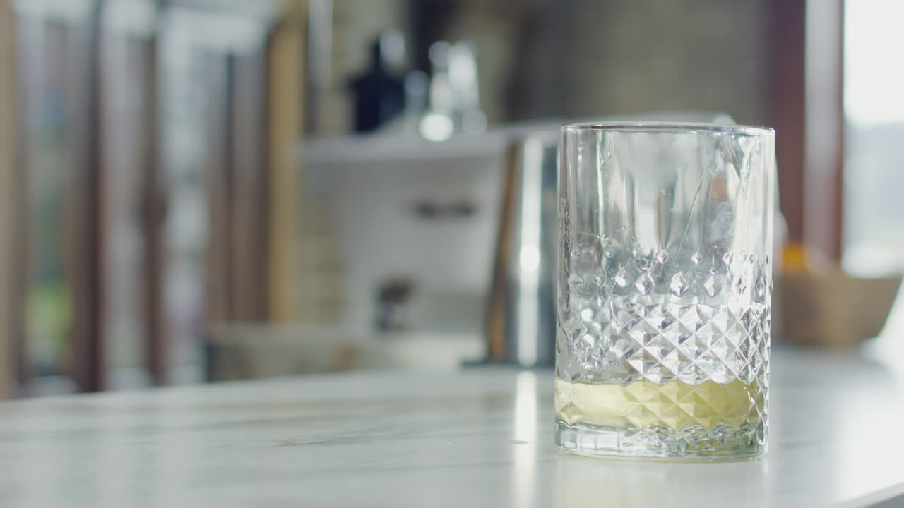 Glass with an alcoholic beverage on a white table in an elegant bar