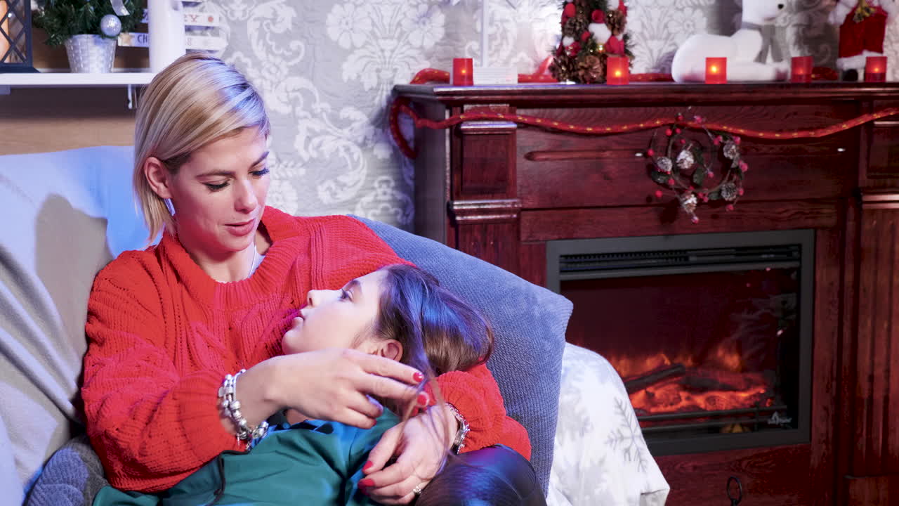 Mother and Daughter Celebrating Christmas by the Fireplace