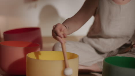 woman playing crystal singing bowls