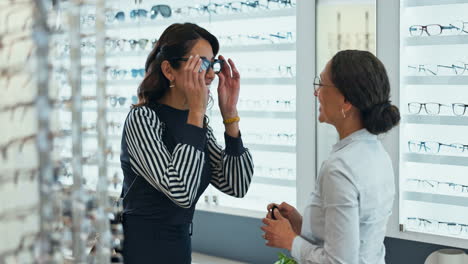 woman trying on glasses at an opticians