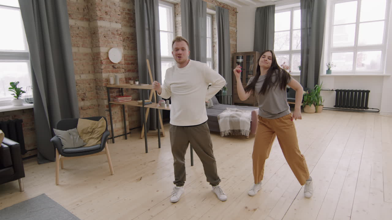 Glade unge mennesker, der danser derhjemme