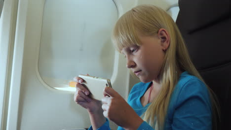 the child plays on the smartphone in the cockpit