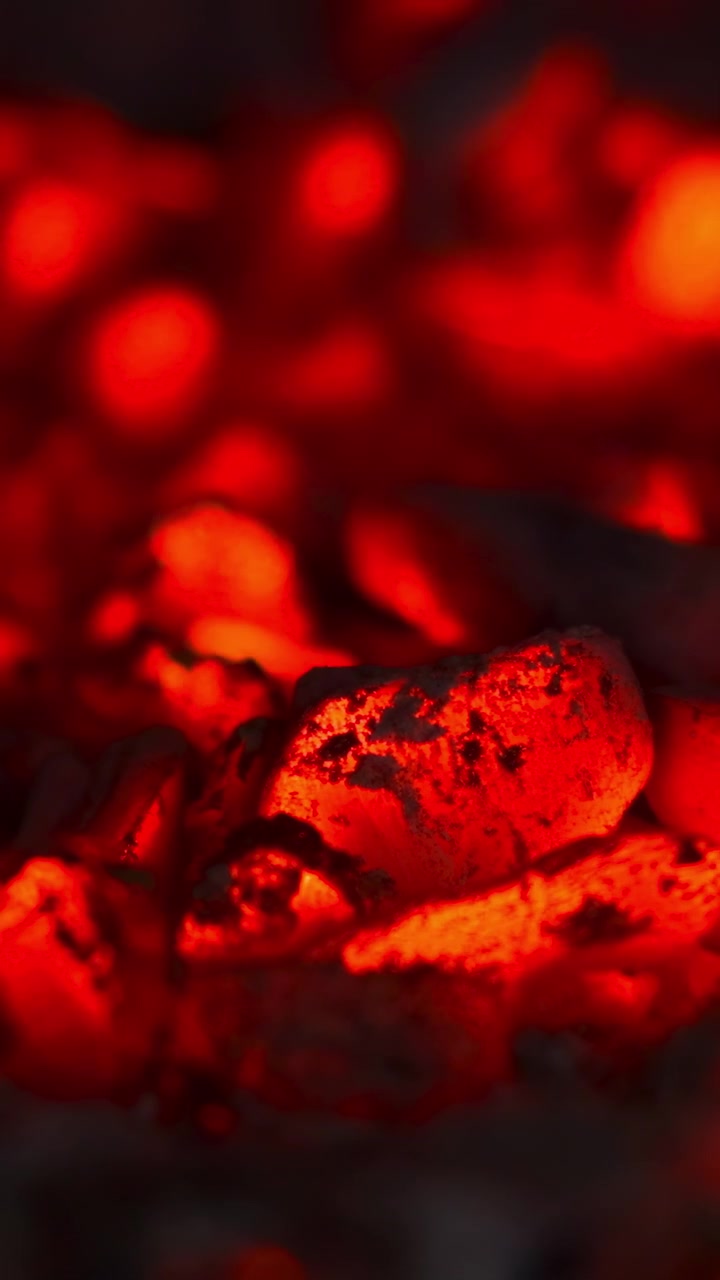 Intense Glowing Coals In Close View, Bright Orange Pockets And Textured Cinder Surrounding Molten Centers