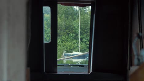 looking out through wheelhouse cabin of wooden boat