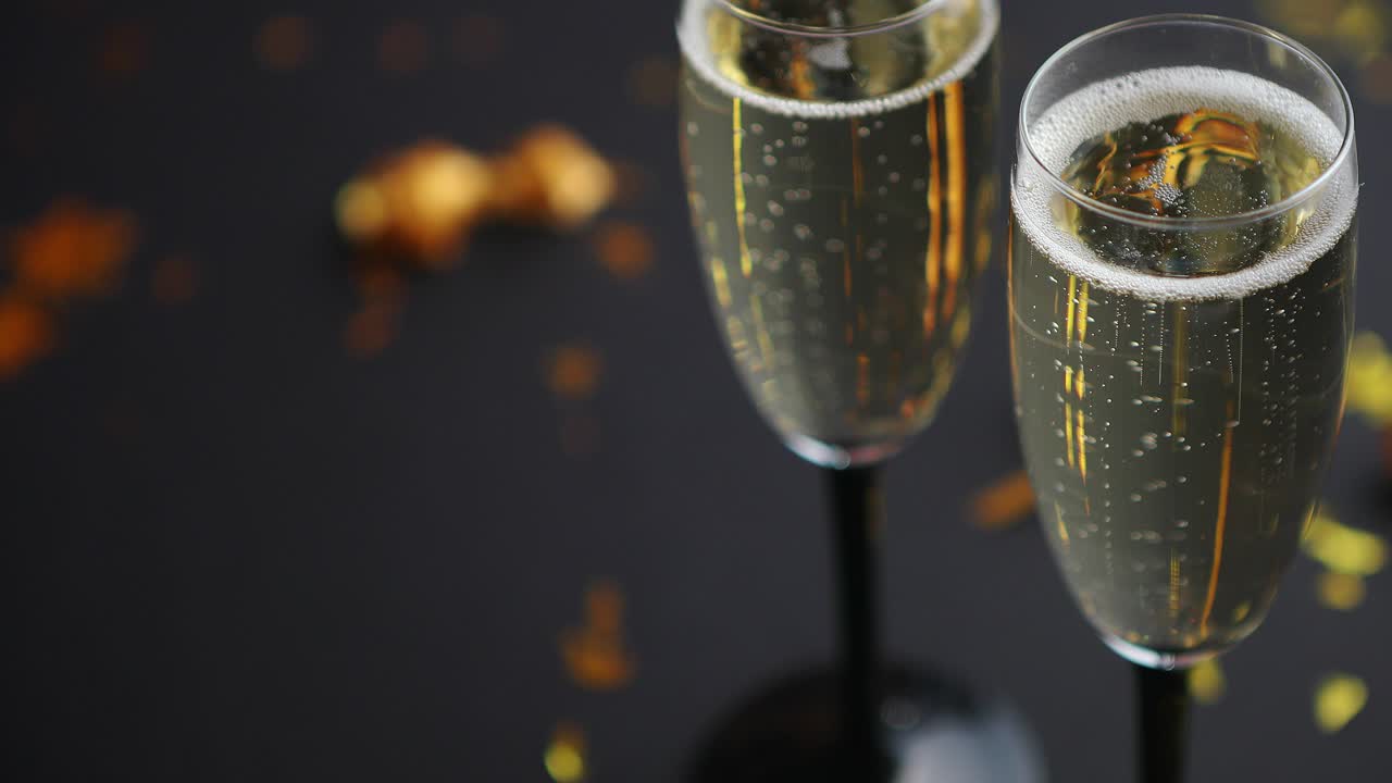Due calici pieni di spumante champagne con decorazioni dorate.