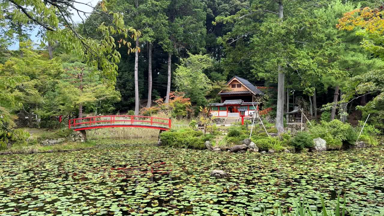 Calm Kyoto Oharano Shrine with pond and red bridge, peaceful nature scene