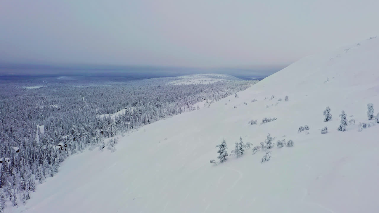 un avión no tripulado volando a lo largo de la nevada luosto cayó, un sombrío día de invierno, en laplandia, finlandia