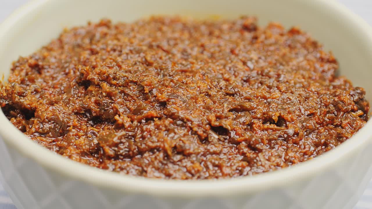 Close-up of a brown spice paste in a bowl