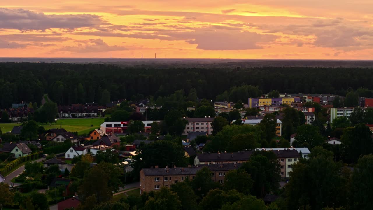 Sunset over Ozolnieki town with orange sky and soviet era aprtment buildings in aerial view